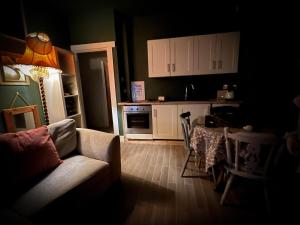 a living room with a couch and a kitchen at The Nook at Ballyward Croft in Ardkeen