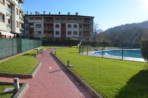 a park with a swimming pool and a building at JayjAstur in Cangas de Onís