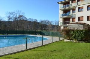 a swimming pool next to a apartment building at JayjAstur in Cangas de Onís