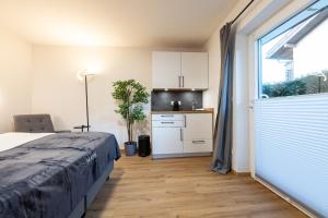 ein Schlafzimmer mit einem Bett und eine Küche mit einem Fenster in der Unterkunft Heu22 Heukammerl in Farchant + 15 Fotos