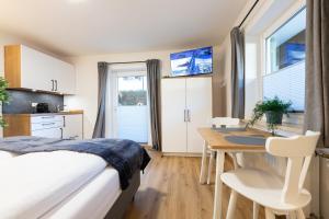 ein Schlafzimmer mit Bett und Tisch und eine Küche in der Unterkunft Heu22 Heukammerl in Farchant