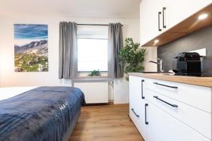 a kitchen with a bed and a sink in a room at Heu22 Herbstgold in Farchant +17 photos