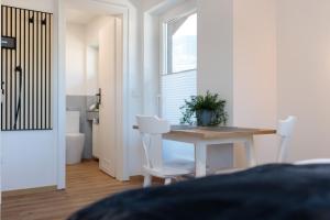 a white room with a table and two white chairs at Heu22 Herbstgold in Farchant