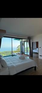 a bedroom with a large bed with a view of the ocean at Love koh tao villa 2 in Koh Tao