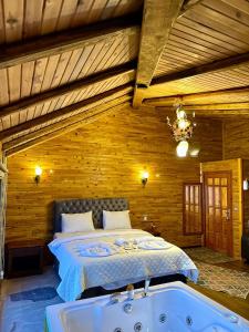 a bedroom with a bed and a bath tub at İsgobya Dağ Evleri 108 in Macka