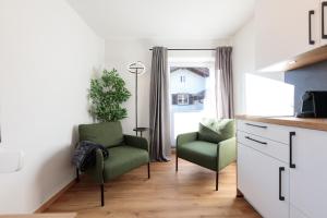 a living room with two chairs and a window at Heu22 Frühlingserwachen in Farchant +20 photos