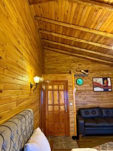 a bedroom with a wooden ceiling with a couch at İsgobya Dağ Evleri 108 in Macka
