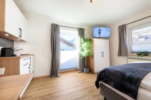 een slaapkamer met een bed en een raam met een tv bij Heu22 Sommerfrische in Farchant