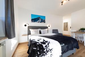 een slaapkamer met een groot bed en een bureau bij Heu22 Sommerfrische in Farchant