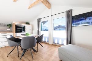 a kitchen with a table and chairs in a room at Heu22 Heuboden in Farchant