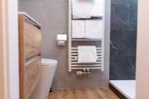 a bathroom with a toilet and towels on a wall at Heu22 Heuboden in Farchant +31 photos