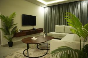 a living room with a bed and a table and a tv at Alpirious in Islamabad