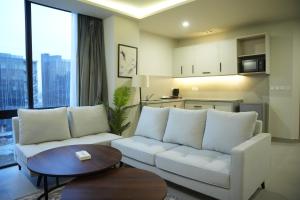 a living room with a white couch and a table at Alpirious in Islamabad