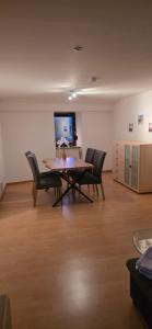 een woonkamer met een tafel, stoelen en een televisie bij Ferienwohnung Chandony in Konz
