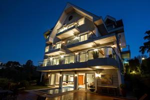 un gran edificio con muchas ventanas por la noche en L.A.H. Hostellerie, en Campos do Jordão