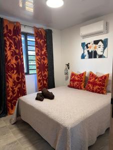 une chambre avec un lit avec des oreillers rouges dans l'établissement Heikauiki home, à Uturoa