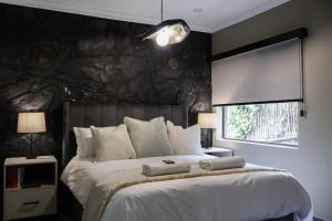 a bedroom with a large bed with a black wall at Fossil Lane in Clarens