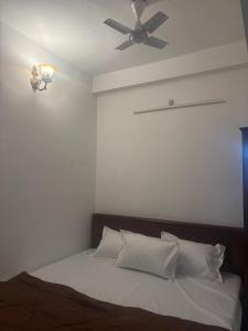 a bedroom with a bed with a ceiling fan at Varson Stay in Pondicherry