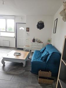 ein Wohnzimmer mit einer blauen Couch und einem Couchtisch in der Unterkunft house in a farmhouse in Sains-lès-Fressin
