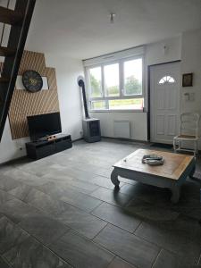 ein Wohnzimmer mit einem Couchtisch und einem TV in der Unterkunft house in a farmhouse in Sains-lès-Fressin