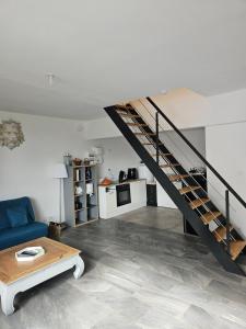 ein Wohnzimmer mit einem blauen Sofa und einer Treppe in der Unterkunft house in a farmhouse in Sains-lès-Fressin