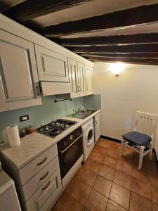 une cuisine avec des armoires blanches et un four à plaques de cuisson dans l'établissement Tre Caravelle, à Levanto