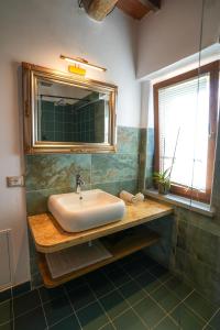 een badkamer met een wastafel en een spiegel bij Sacro e Profano Albania in Zikxhafaj