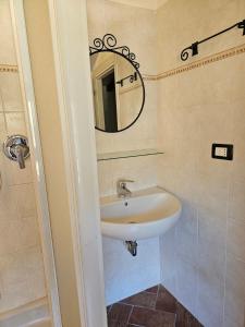 une salle de bains avec un lavabo et un miroir dans l'établissement Tre Caravelle, à Levanto