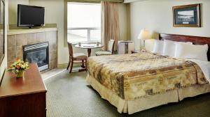 een hotelkamer met een bed en een open haard bij Nova Inn Peace River in Peace River