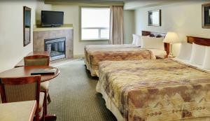 een hotelkamer met 2 bedden en een open haard bij Nova Inn Peace River in Peace River