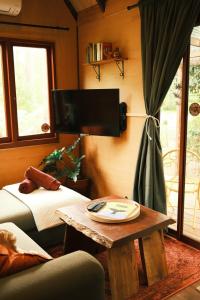 a living room with a table and a bed and a tv at Rancho Relaxo Tiny House - in town sanctuary in Margaret River Town