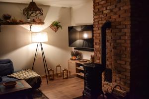 a living room with a fireplace and a brick wall at Siedlisko nad Cisowcem Bieszczady in Cisowiec
