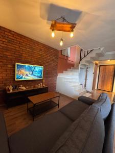 un salon avec un canapé et un mur de briques dans l'établissement Central Cozy Villa 5 Min to Beach, à Kusadası