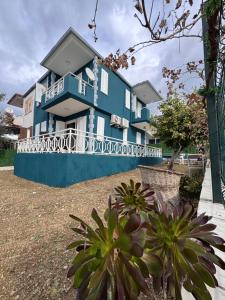 une maison bleue avec une clôture devant elle dans l'établissement Central Cozy Villa 5 Min to Beach, à Kusadası