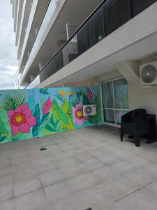 a room with a mural of flowers on the wall at Peperina 2 villa Carlos paz in Villa Carlos Paz