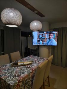 a dining room table with a television in a living room at Peperina 2 villa Carlos paz in Villa Carlos Paz