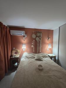 a bedroom with a large bed with orange walls at Peperina 2 villa Carlos paz in Villa Carlos Paz