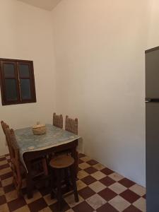 eine Küche mit Tisch und Stühlen und einem Kühlschrank in der Unterkunft Riad TiznitSouss in Tiznit