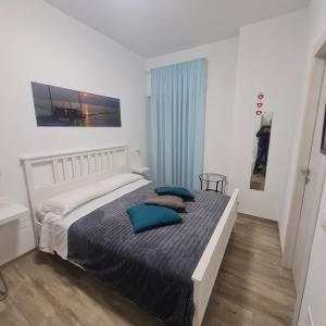 een slaapkamer met een bed met blauwe kussens erop bij B&B Battisti59 in Vieste