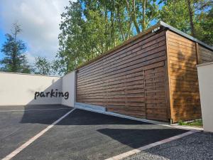 een parkeerplaats met een groot houten gebouw bij Gîte Le Carré 17 in Lillers