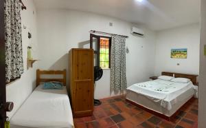 een slaapkamer met twee bedden en een raam bij Pousada Casa do Josef in Canoa Quebrada