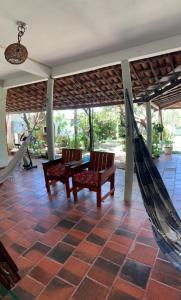 een veranda met 2 stoelen en een hangmat bij Pousada Casa do Josef in Canoa Quebrada