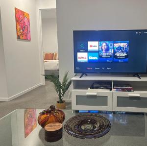 een woonkamer met een flatscreen-tv op een entertainmentcentrum bij Lake Views Belconnen in Belconnen