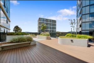 een balkon van een gebouw met een houten terras bij Lake Views Belconnen in Belconnen