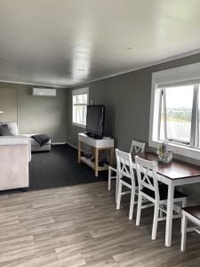 a living room with a table and chairs and a bed at Hideaway on Honikiwi in Otorohanga