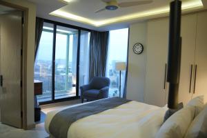 a bedroom with a bed and a chair and a window at Alpirious in Islamabad