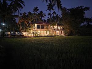 a house in the middle of a field at night at Bhoomi by Ostello in Varkala