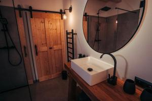 a bathroom with a sink and a mirror on a counter at Cozy Chalet in Smolné Pece