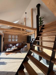 a wooden staircase in a room with a living room at Cozy Chalet in Smolné Pece