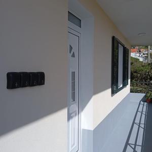 a white house with a door and a balcony at Yellow Owl II - Bedroom III in Campanário